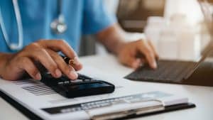 Doctor calculating expenses